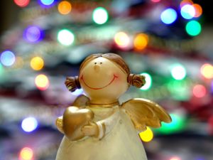 Angel ornament with a blurry Christmas tree in the background